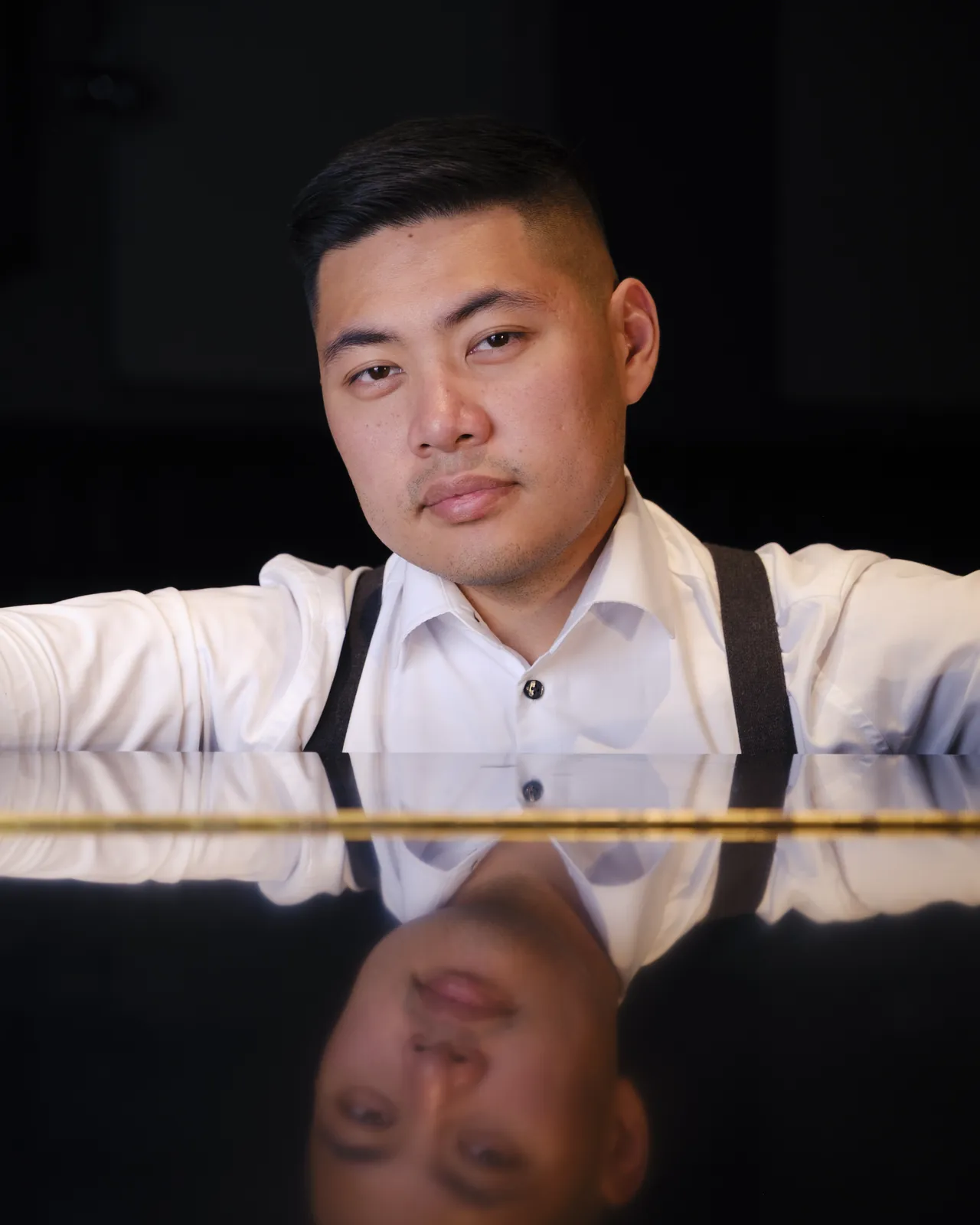 Isaac Ezekiel behind a grand piano